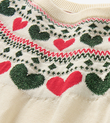 Close-up of cream knit neckline with red hearts and green heart Fair Isle-style pattern