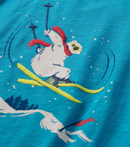 Close-up of skiing bear graphic with red scarf and yellow skis on blue T-shirt