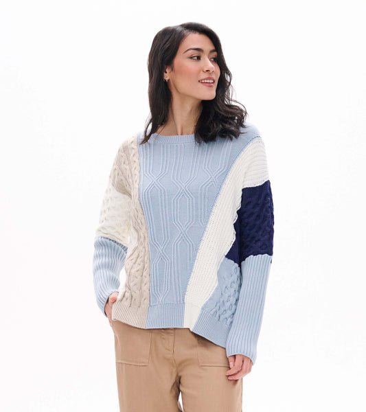 Front view of blue mixed-pattern sweater with cream, beige and navy textured panels