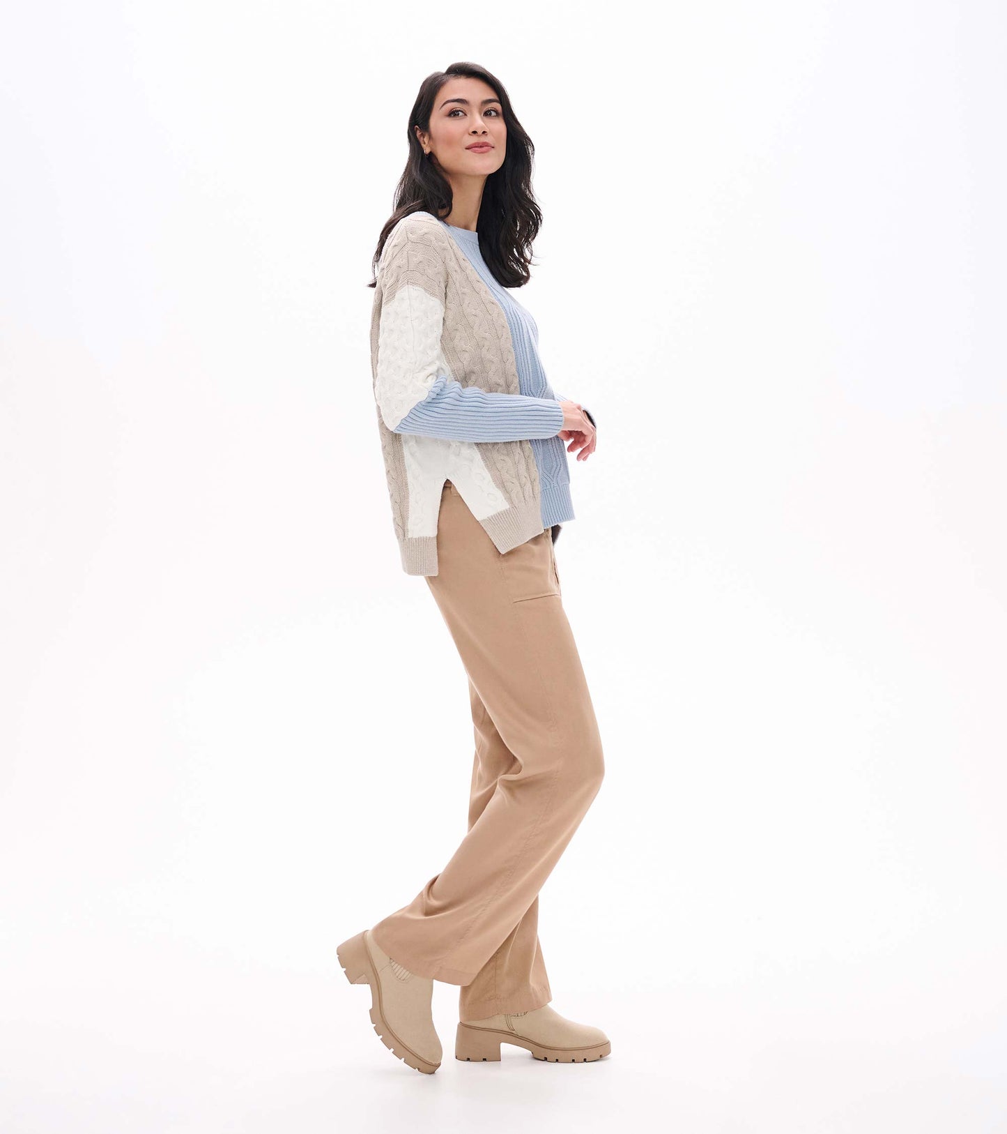 Side view of blue mixed-pattern sweater showing split hem and mixed cable and textured knit panels