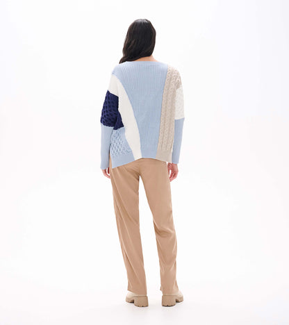 Back view of blue mixed-pattern sweater with cream, beige and navy textured panel details