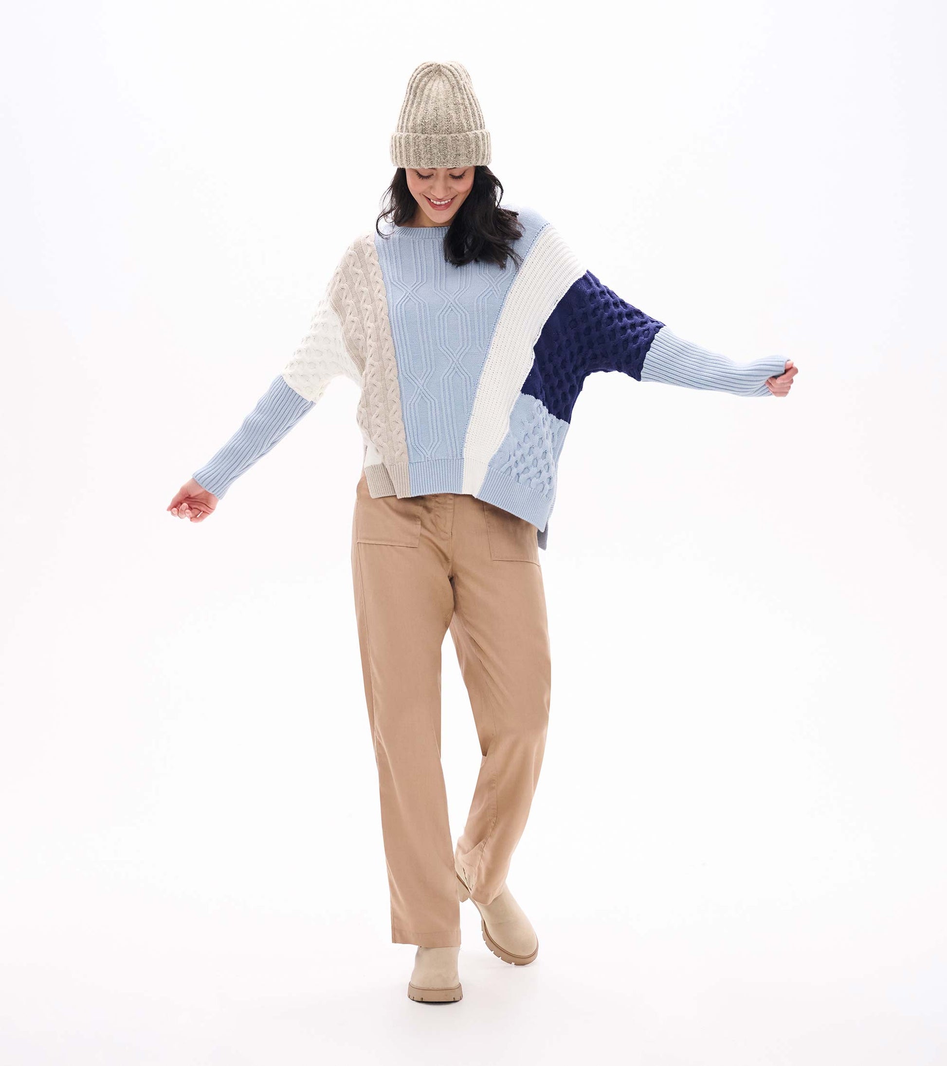 Front view of mixed pattern sweater in light blue, cream, and navy with varied knit textures and long sleeves