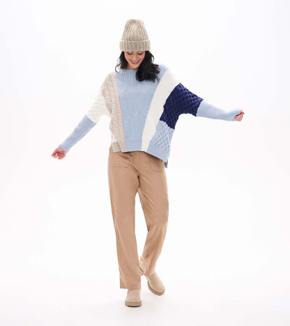Front view of mixed pattern sweater in light blue, cream, and navy with varied knit textures and long sleeves