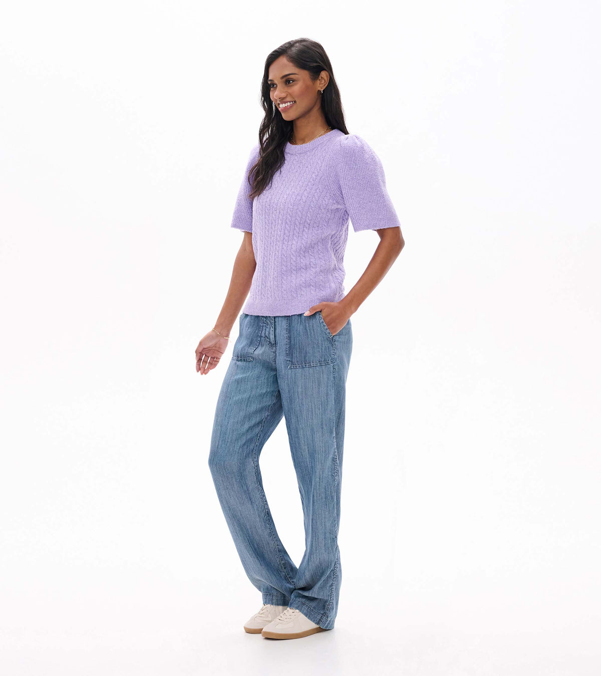 Model wearing lilac cable knit sweater with short sleeves, angled side view