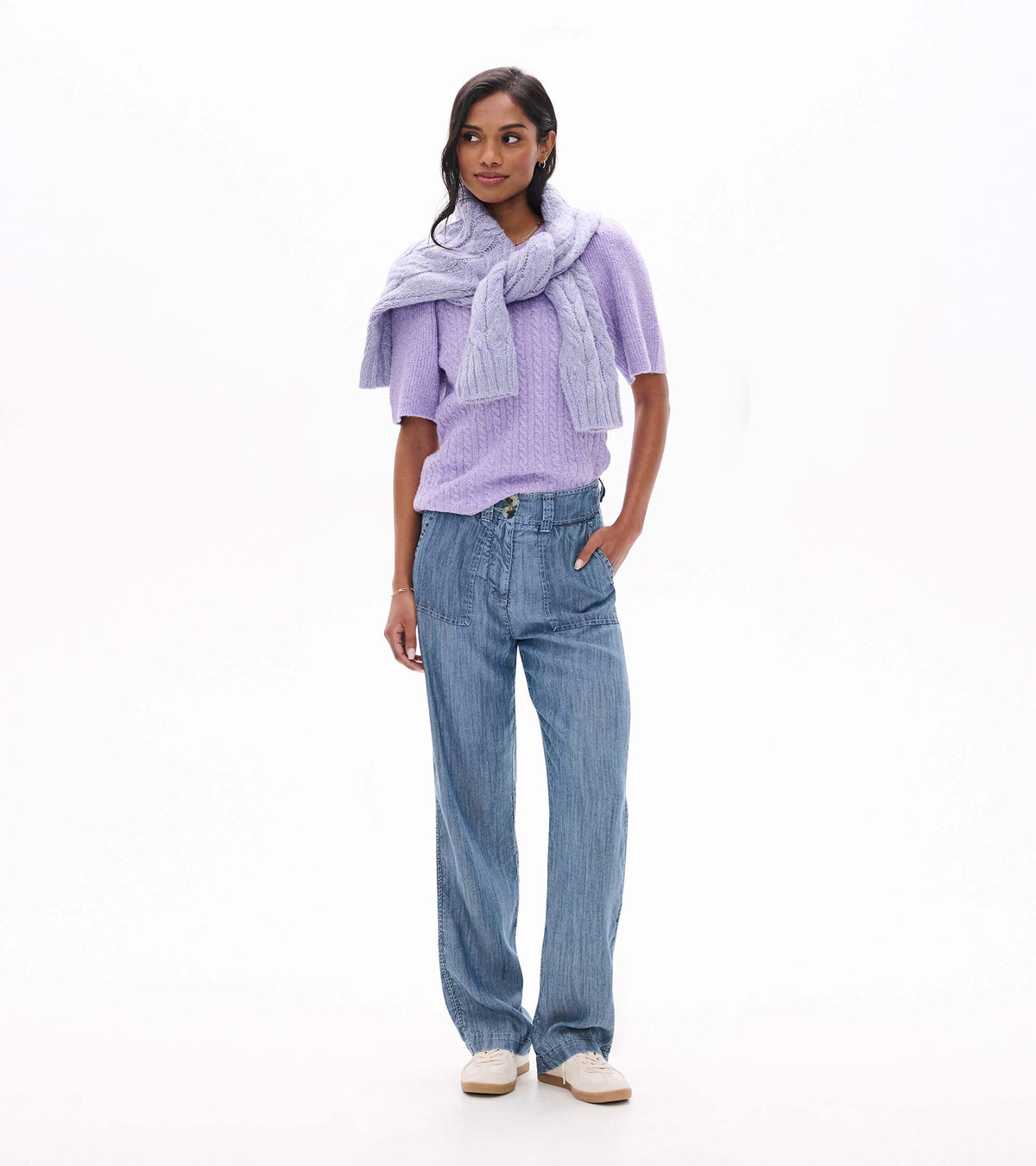 Model wearing lilac cable knit sweater with a matching sweater draped over shoulders