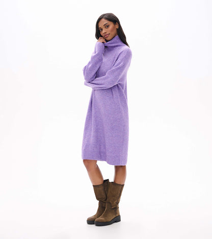 Model wearing lilac melange sweater dress with high neck and long sleeves, angled front view