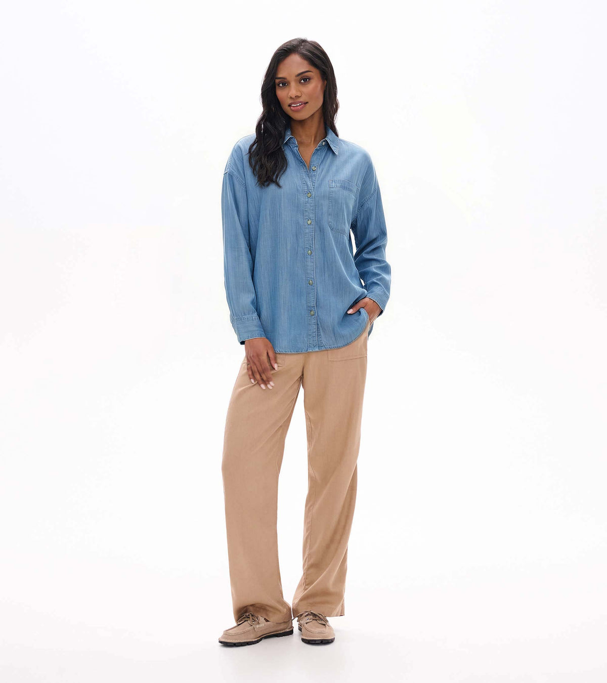 Full front view of light blue wash relaxed button-down shirt styled with tan pants