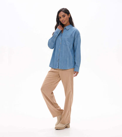 Angled front view of light blue wash relaxed button-down shirt with chest pocket and long sleeves