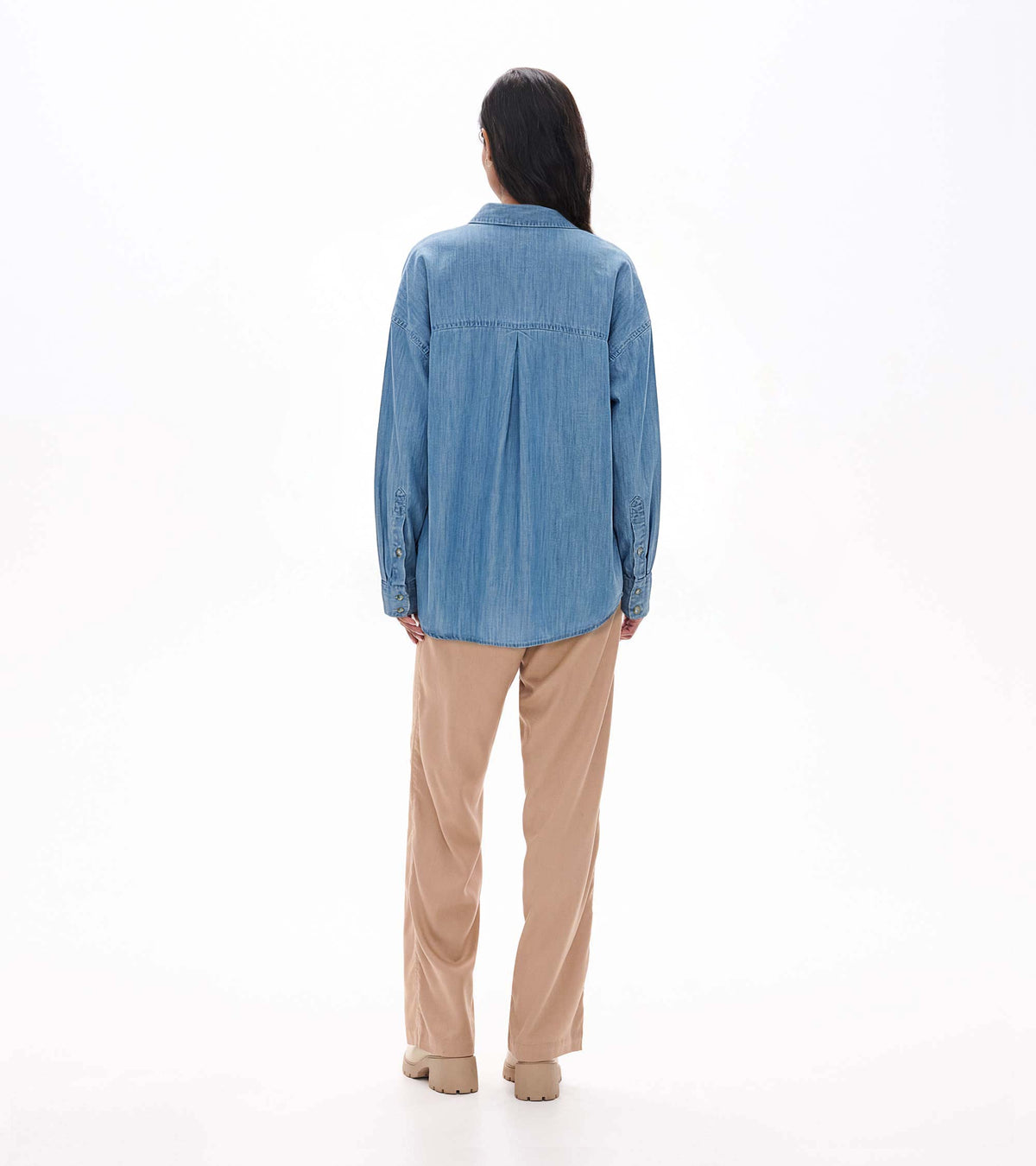 Back view of light blue wash relaxed button-down shirt with yoke seam and center back pleat