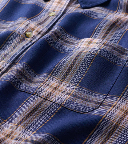 Close-up of navy plaid shirt showing chest pocket, buttons, and plaid pattern detail