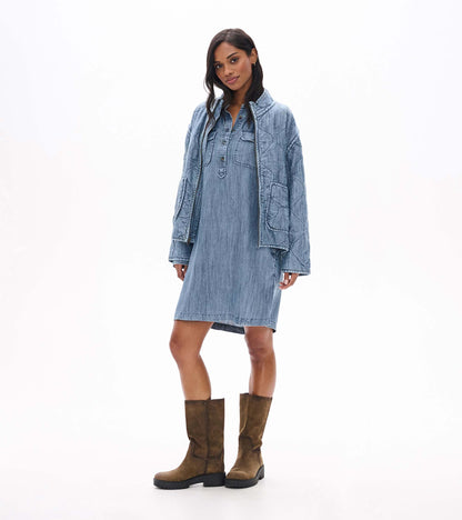 Blue acid rinse popover dress with a partial button placket and chest pockets, shown front view under a jacket
