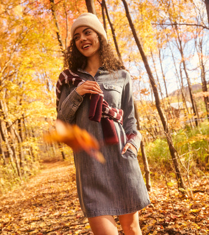 Blue acid rinse popover dress worn outdoors with a knit hat and striped sweater draped over shoulder