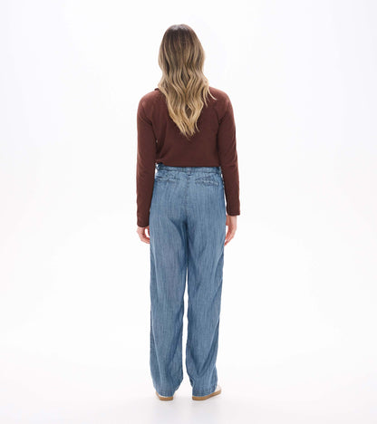 Back view of blue acid rinse wide leg pants with rear welt pockets and a relaxed full-length fit