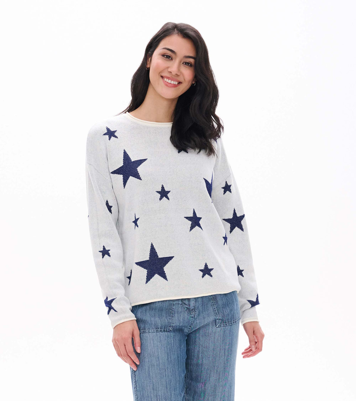 Front view of cream rolled edge sweater with navy star pattern, shown on model