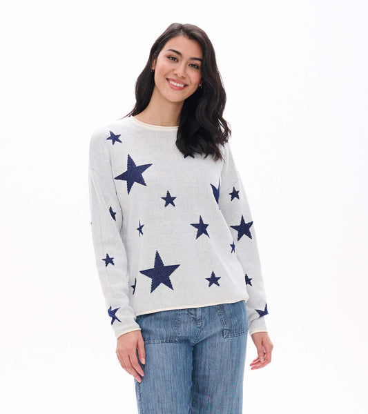 Front view of cream rolled edge sweater with navy star pattern, shown on model