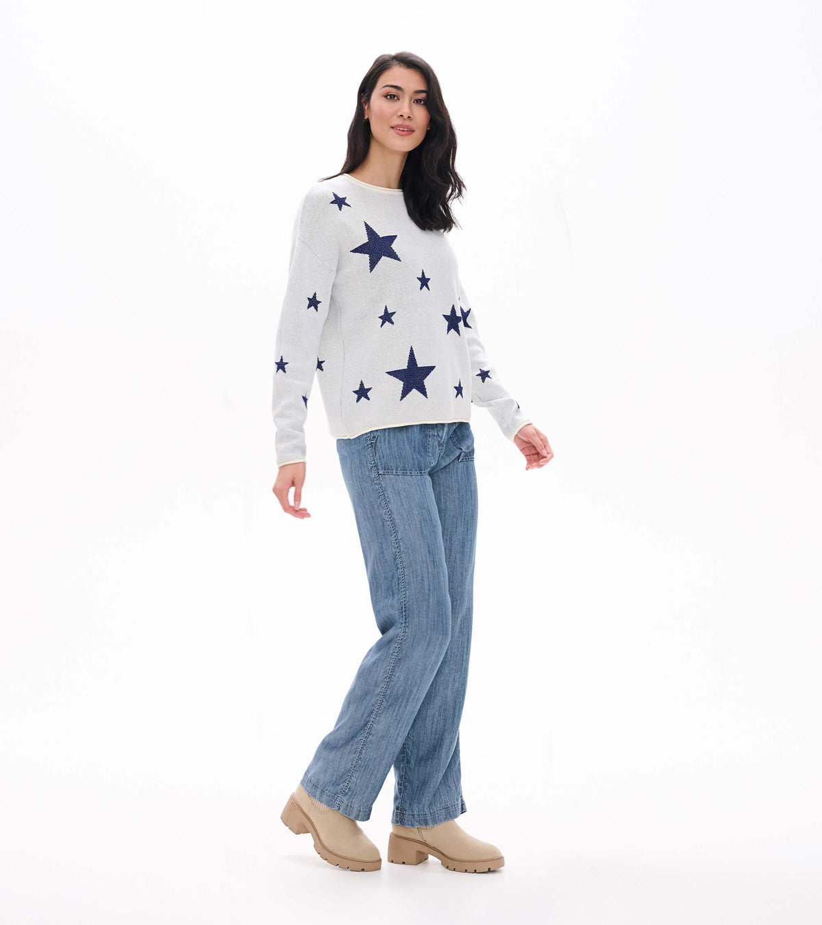 Angled front view of cream sweater with navy stars, shown on model