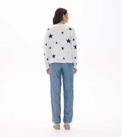 Back view of cream rolled edge sweater with navy star pattern, shown on model