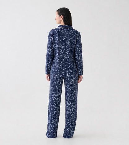 Back view of navy polka dot pajama set with long sleeve top and straight leg pants