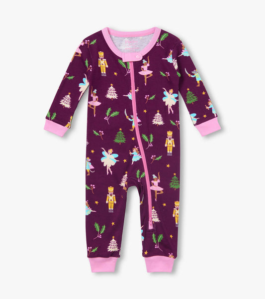 Front view of plum baby coverall with pink trim and zipper, printed with nutcrackers, ballerinas, trees and holly