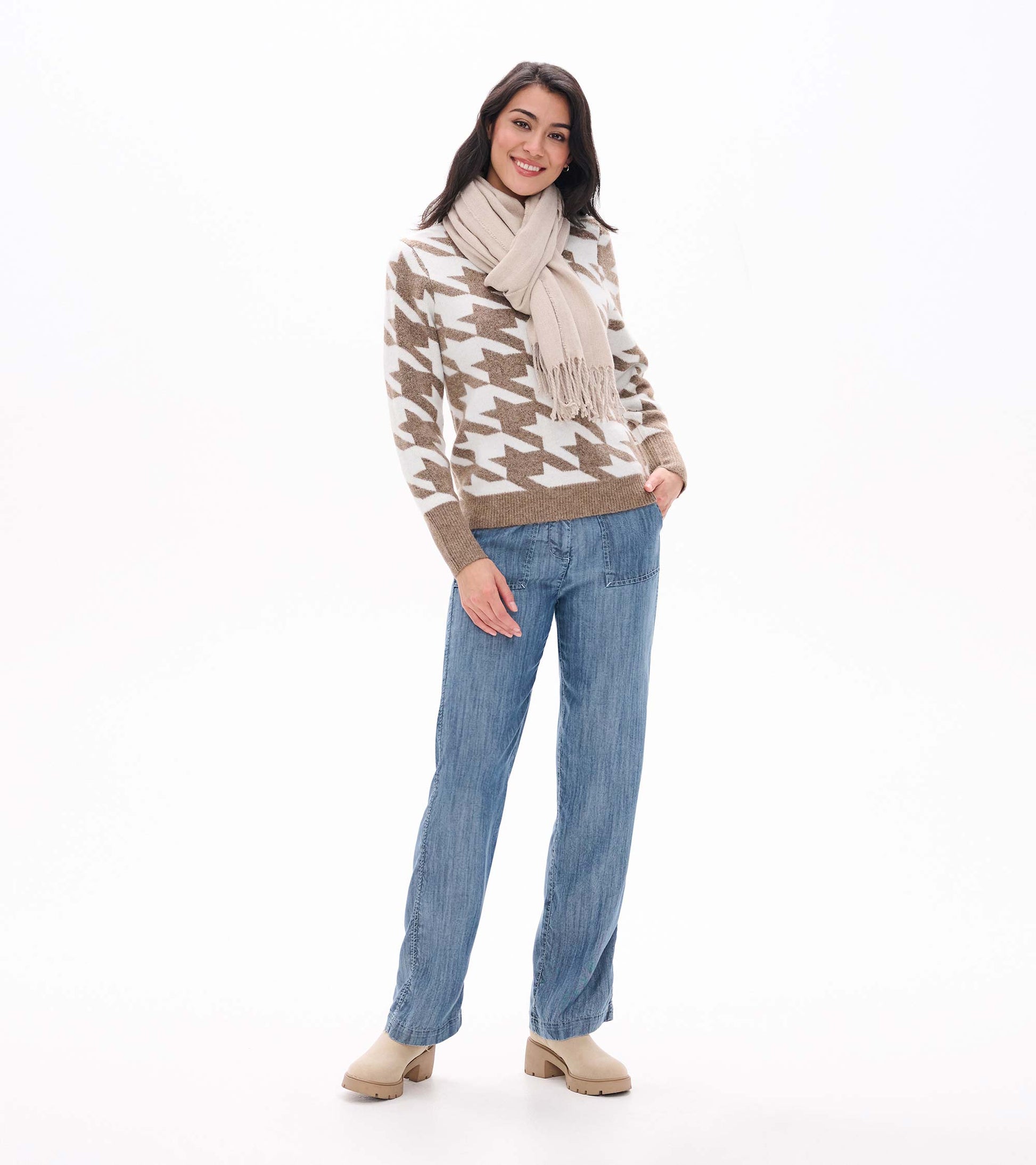 Front view of oatmeal and cream herringbone sweater styled with a beige scarf