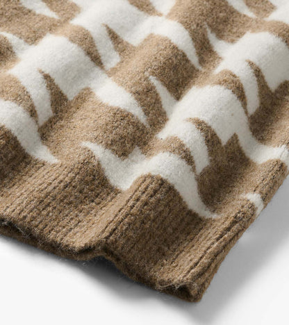 Close-up of oatmeal and white herringbone sweater knit with ribbed hem detail