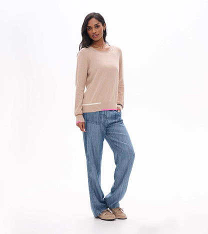 Full front view of oatmeal crew neck sweater with ribbed hem and contrast trim, styled with blue wide-leg pants