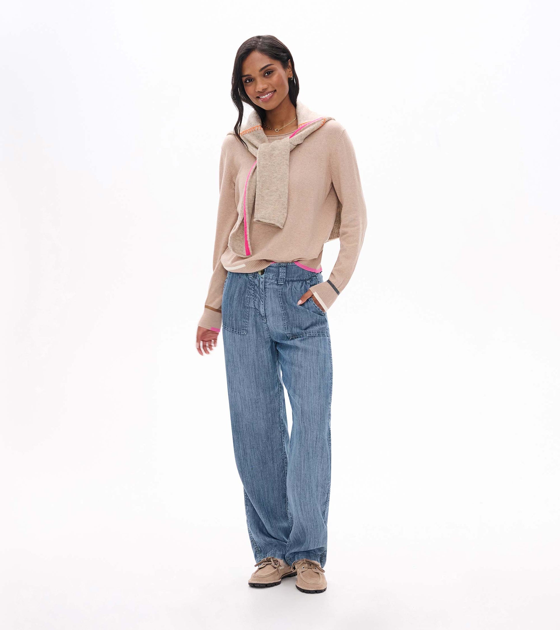 Model wearing oatmeal melange crew neck sweater with pink trim, styled with blue wide-leg pants