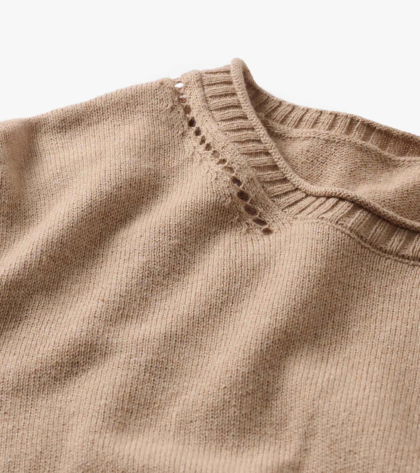 Close-up of oatmeal melange crew neck sweater with ribbed collar and openwork detail at the shoulder