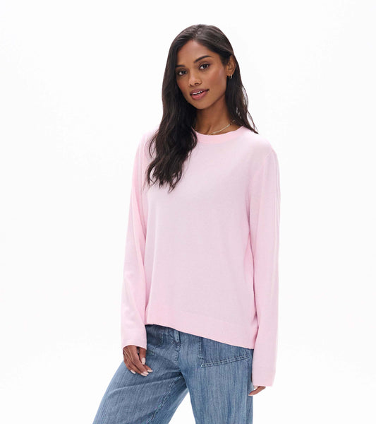 Model wearing pale pink boyfriend sweater with crew neck, long sleeves, and ribbed hem