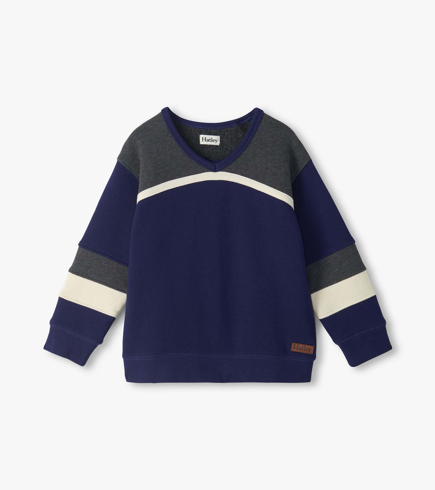 Front view of boys blue pullover top with gray yoke, curved cream stripe, and striped long sleeves