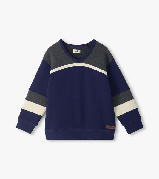 Front view of boys blue pullover top with gray yoke, curved cream stripe, and striped long sleeves