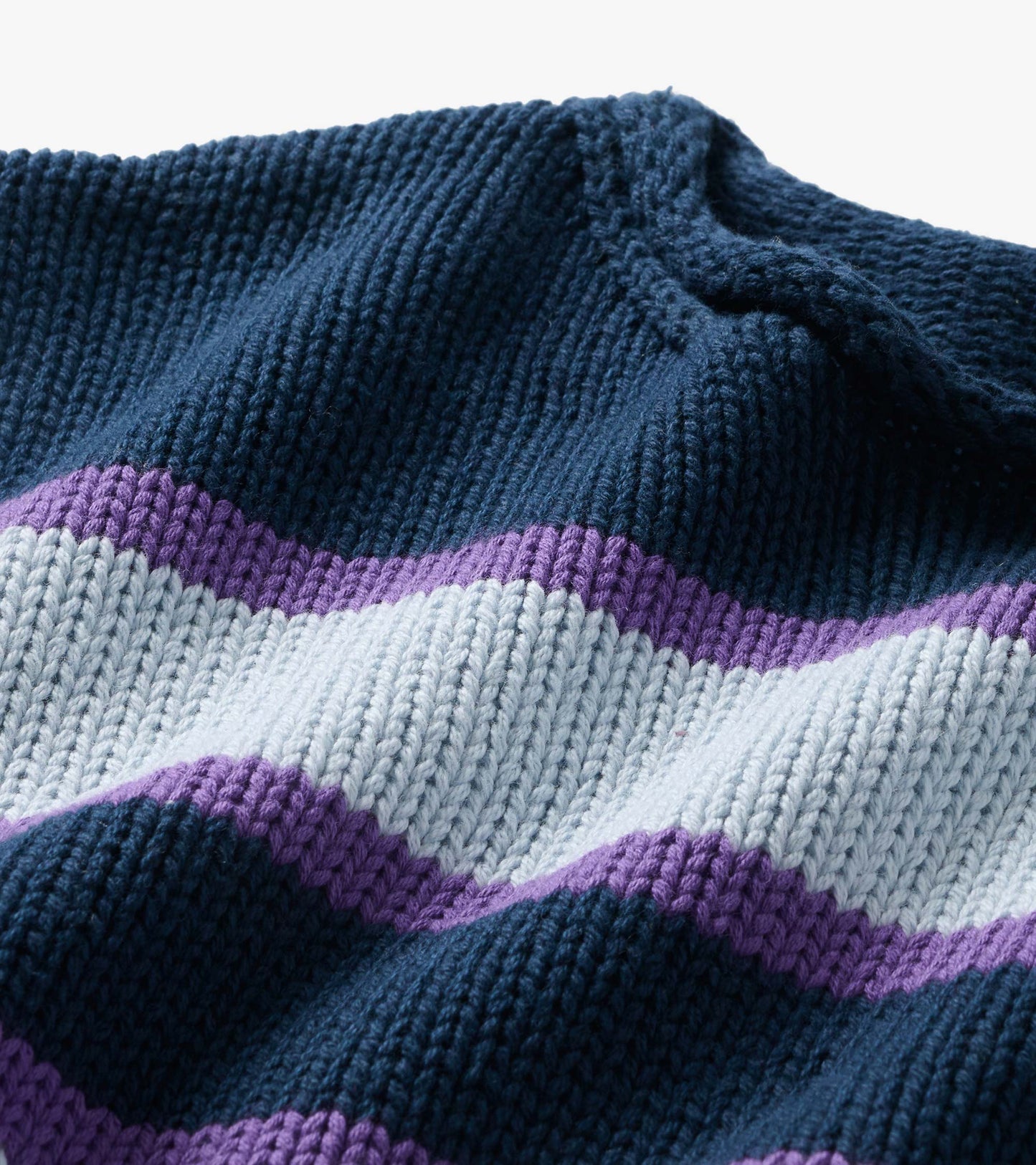 Close-up of rolled collar knit sweater with navy, white, and purple stripes