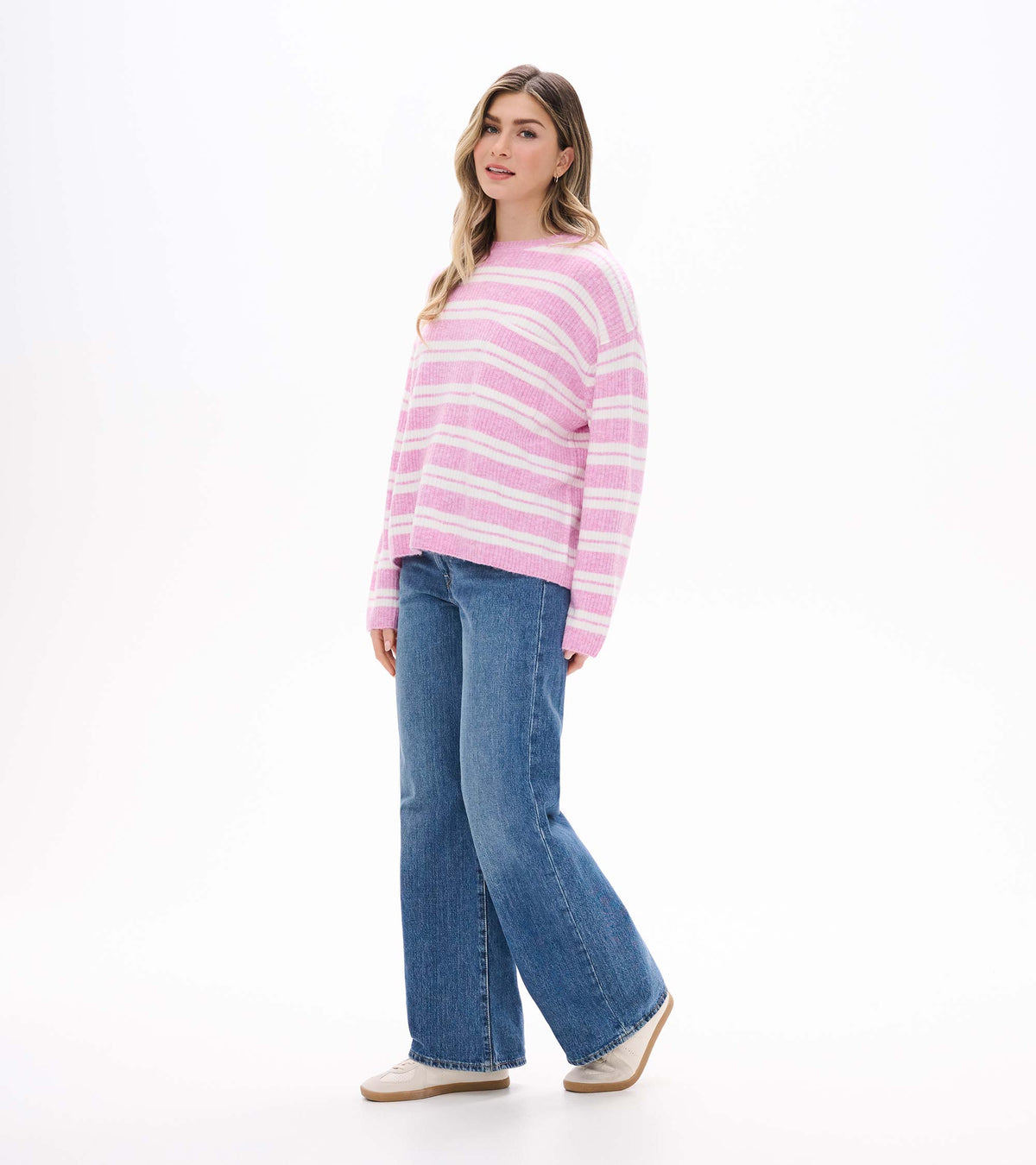 Side view of pink and cream striped sweater with crew neck and slightly dropped shoulders