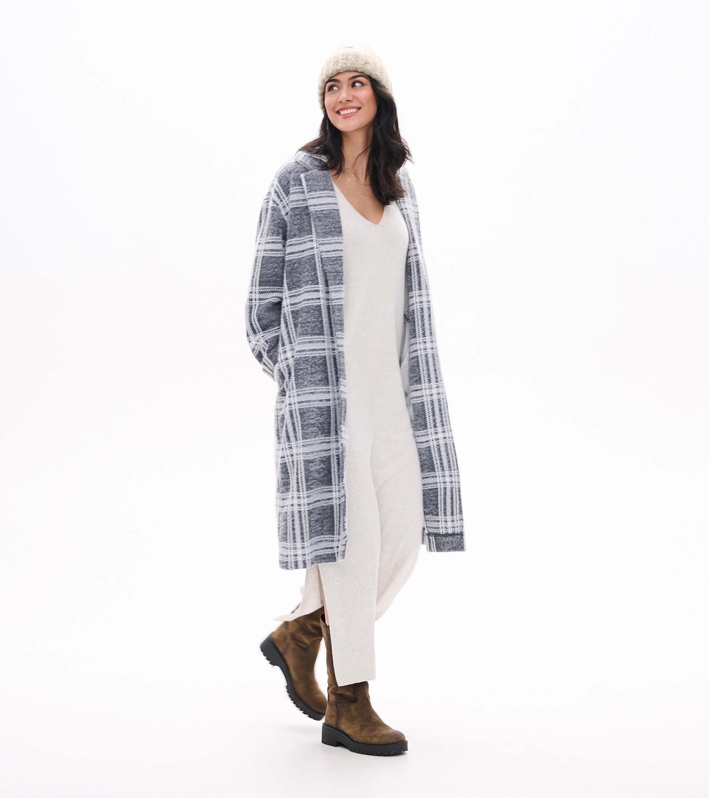 Pale grey melange sweater dress with V-neck and side slit, shown layered under a grey plaid coat