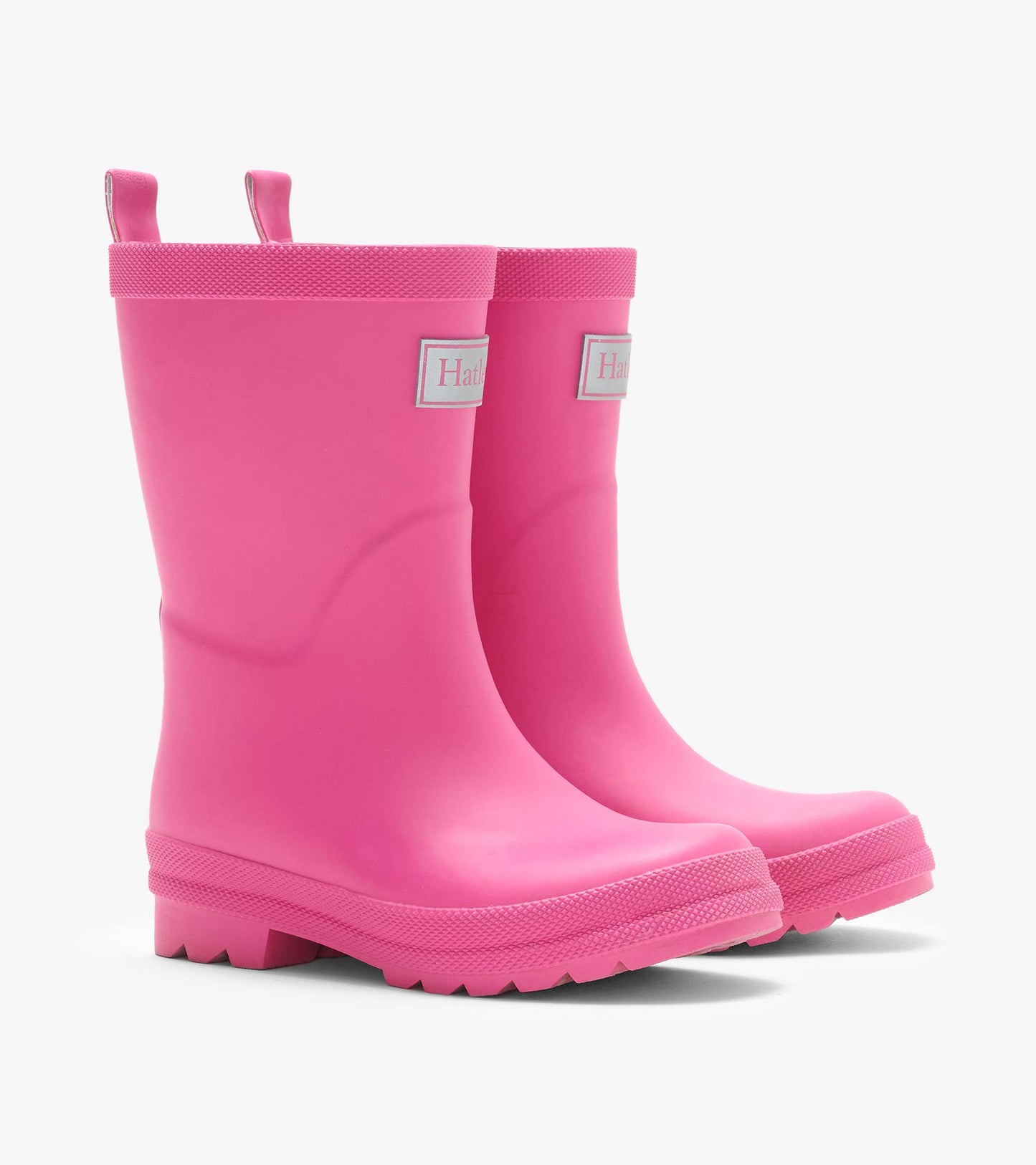 Pair of pink matte rain boots with textured trim, pull tabs, and lug soles, angled front view