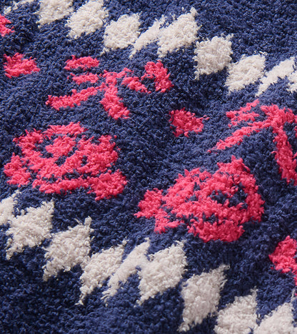 Close-up of navy sweater dress with pink bow and rose pattern and white diamond details
