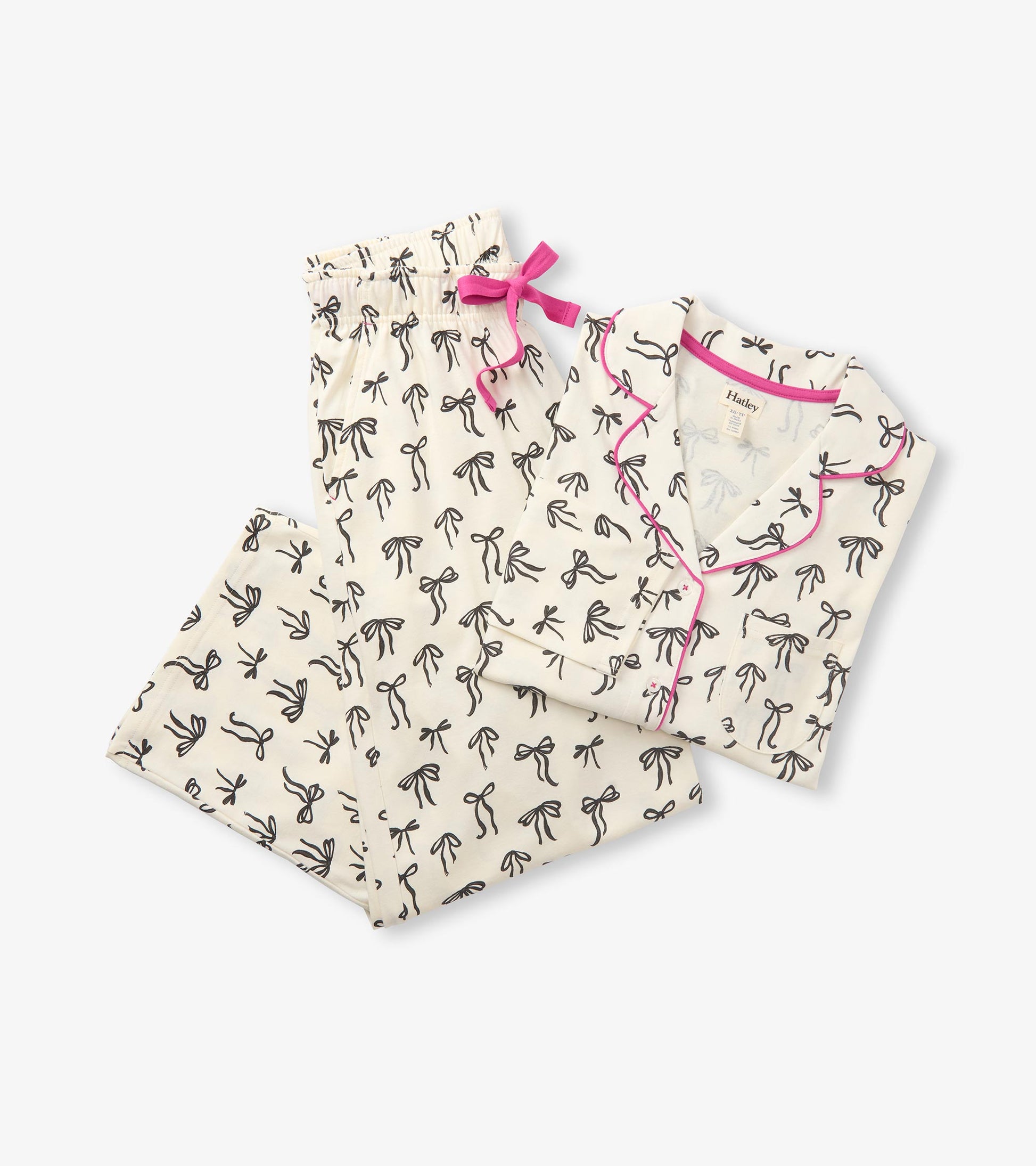 Cream pajama set with black bow print, pink piping, and matching pants with a pink waist tie