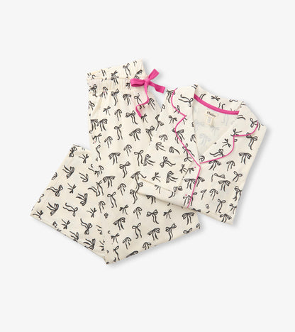 Cream pajama set with black bow print, pink piping, and matching pants with a pink waist tie
