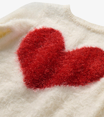 Close-up of red heart graphic on cream fuzzy knit sweater