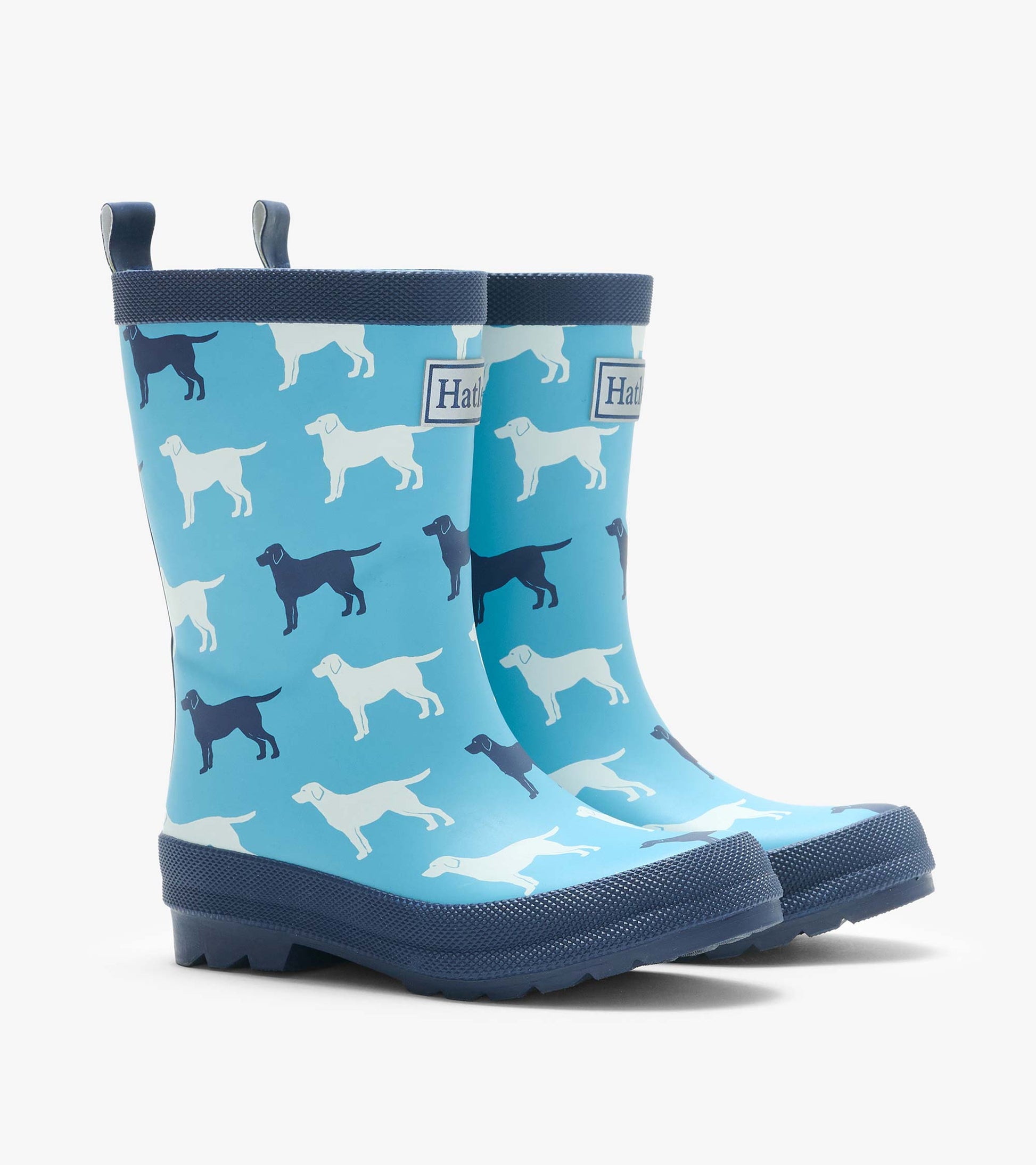 Pair of blue rain boots with navy soles and white and navy dog silhouettes, angled front view