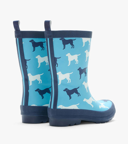 Pair of blue rain boots with white and navy dog silhouettes, shown from the back side