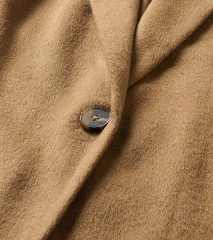 Close-up of the burro brown jacket showing the button and soft brushed surface