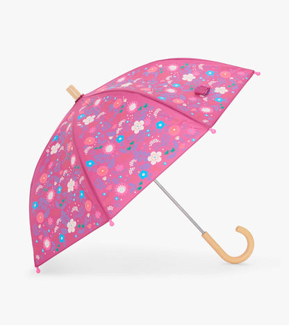 Open pink kids umbrella with tiny multicolor floral print and curved light wood handle