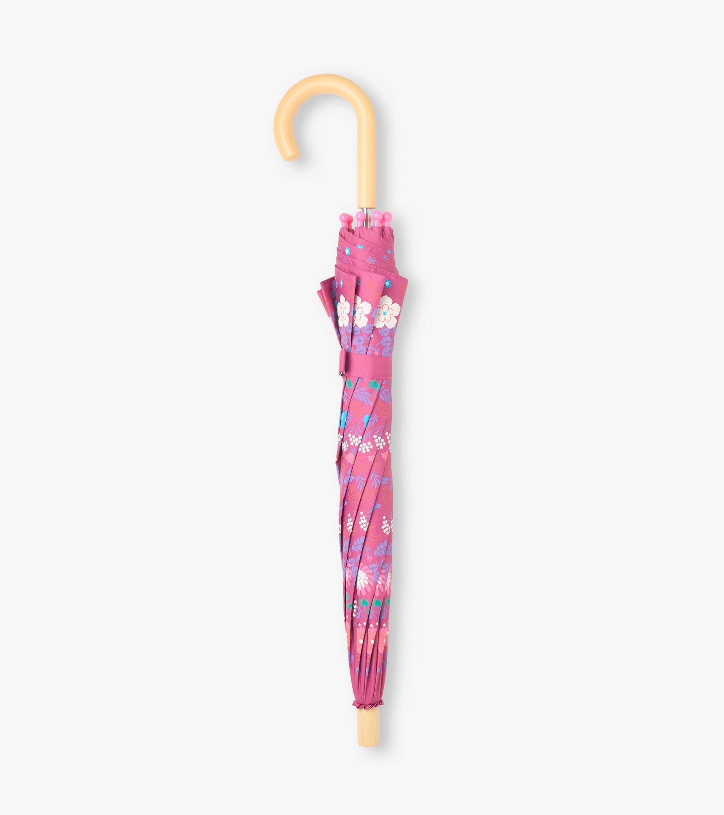Closed pink umbrella with tiny floral print, matching strap, and curved light wood handle