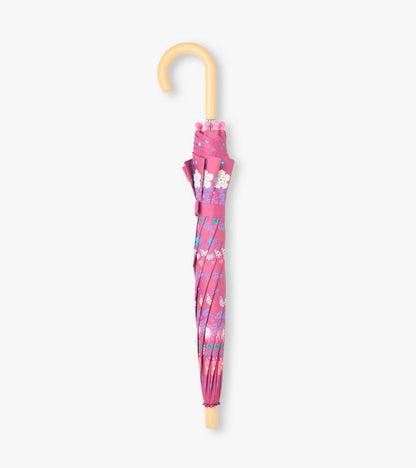 Closed pink umbrella with tiny floral print, matching strap, and curved light wood handle