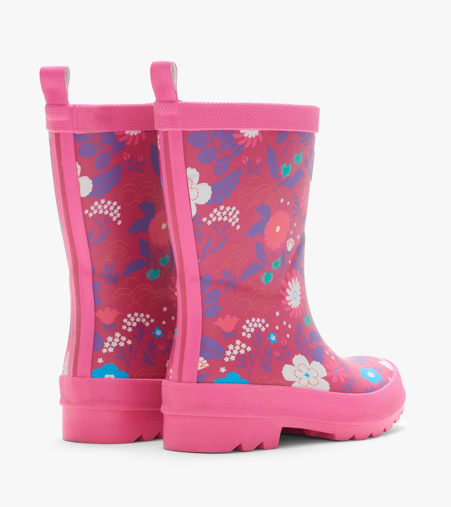Rear side view of pink kids rain boots with tiny floral print, back pull tabs, and thick treaded soles