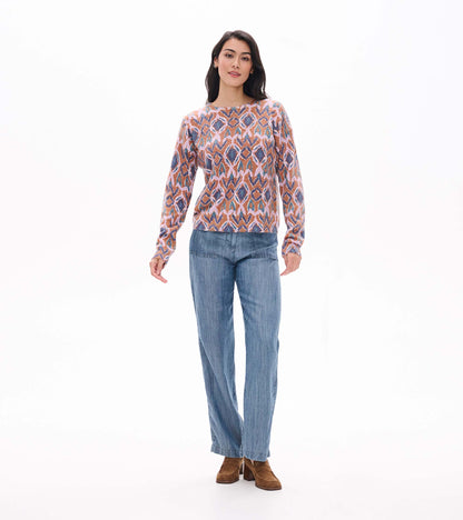 Full front view of Noa ikat sweater styled with wide leg blue pants