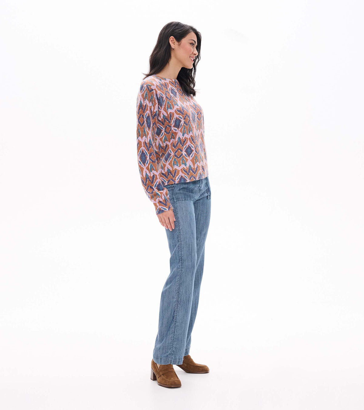 Side view of patterned long sleeve sweater in pink, blue and rust tones