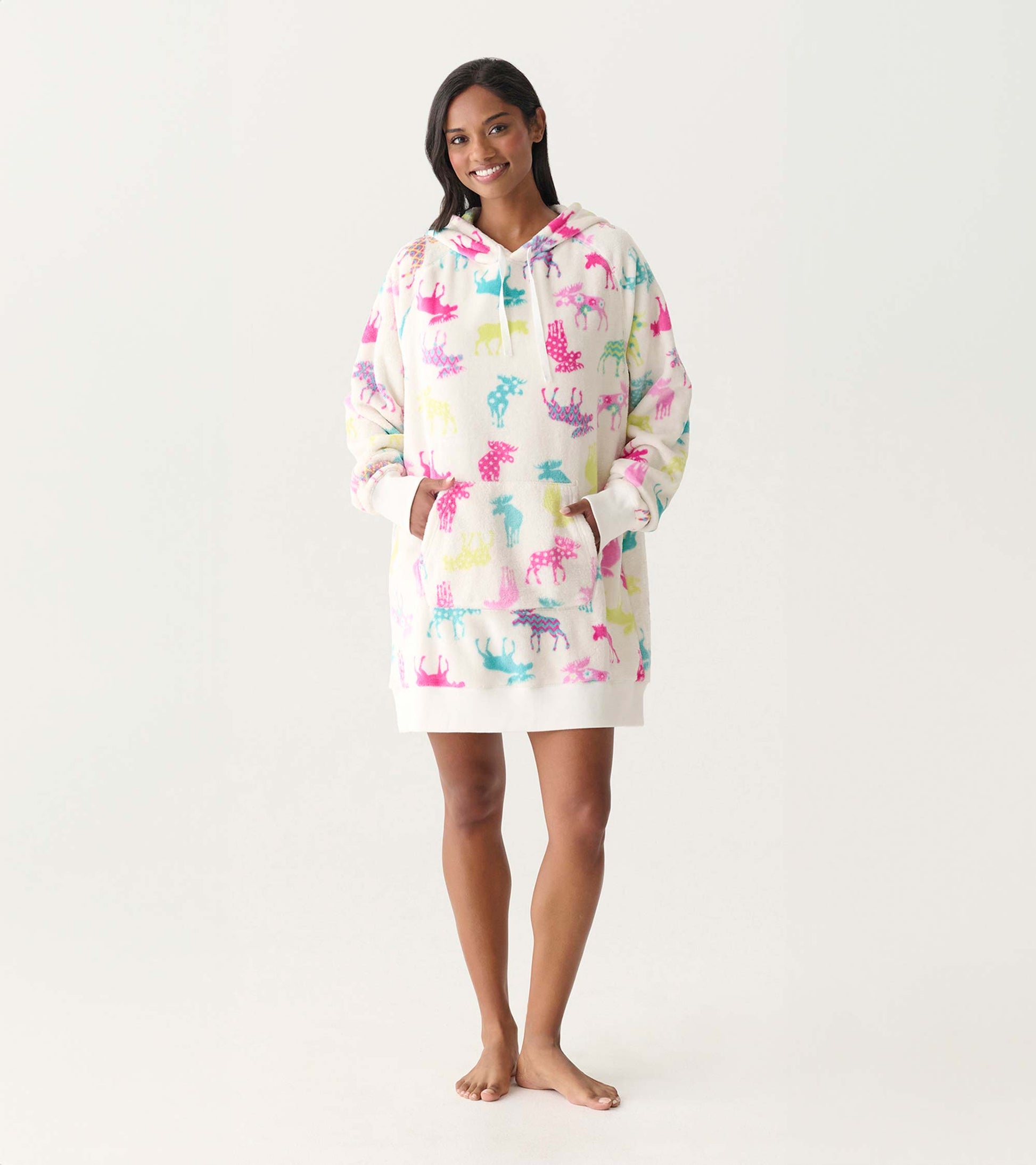 White oversized hoodie dress with colorful moose print, hood, front pocket, and long sleeves on a model