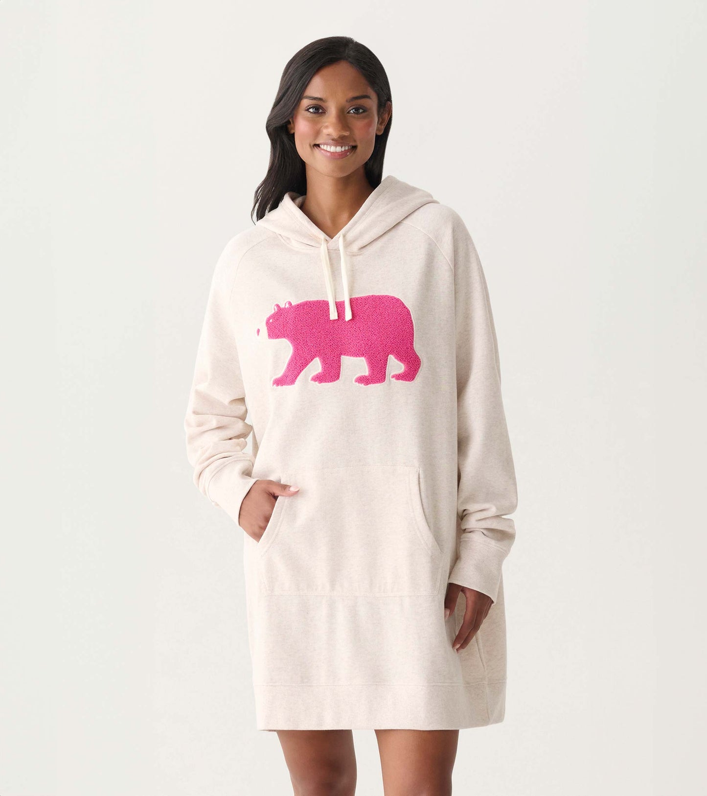 Oversized cream hoodie dress with hood, kangaroo pocket, and bright pink bear graphic on the front